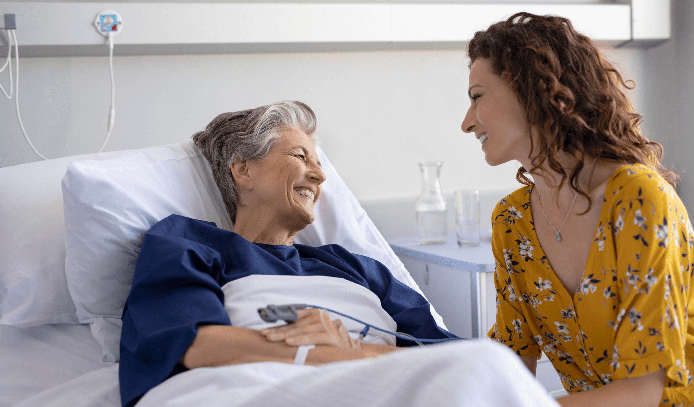 GettyImages-2174052664 1 (1) (1) A woman and an old lady in a hospital bed