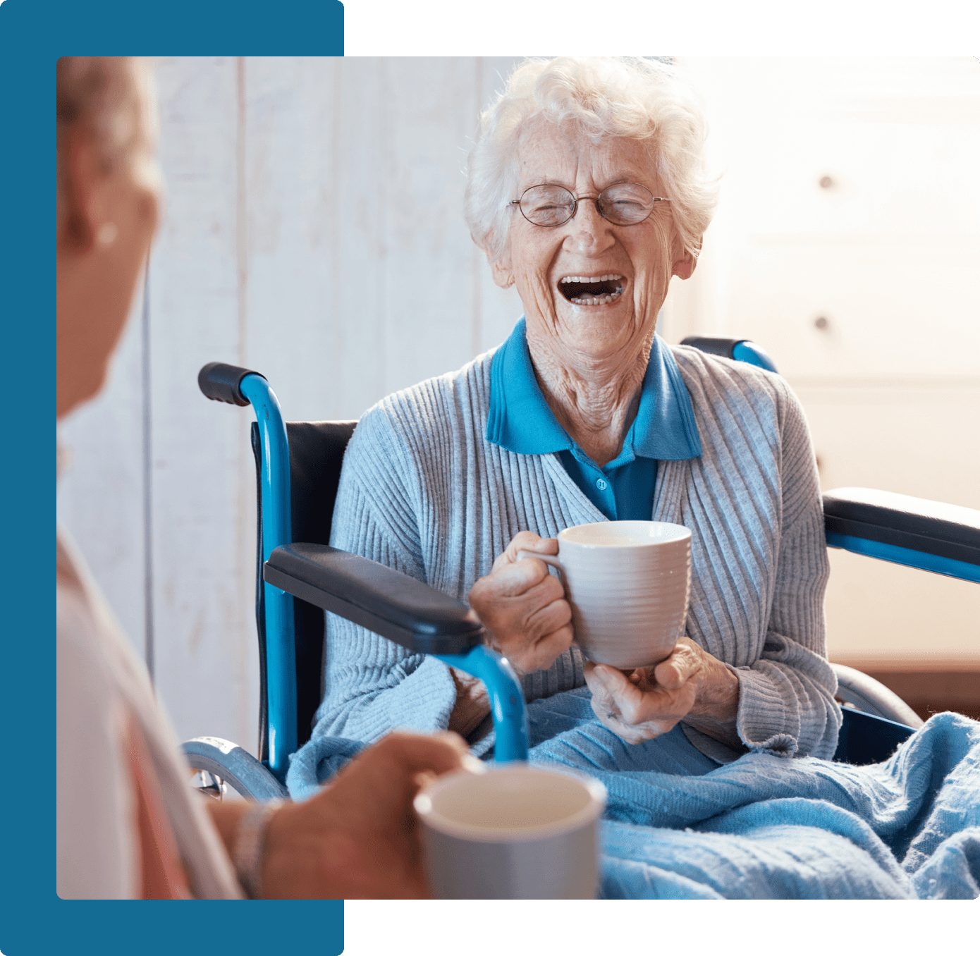 Group 24 A woman sitting in a wheelchair holding a cup.