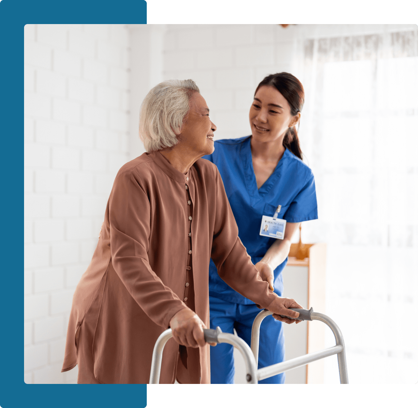 Group 7 A woman in blue scrubs helping an older person walk.