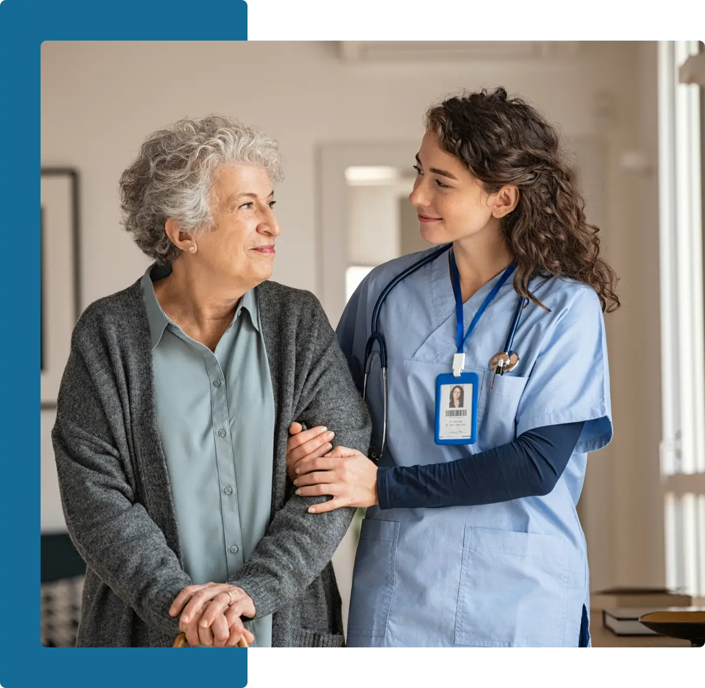 A nurse and an older woman in blue scrubs.