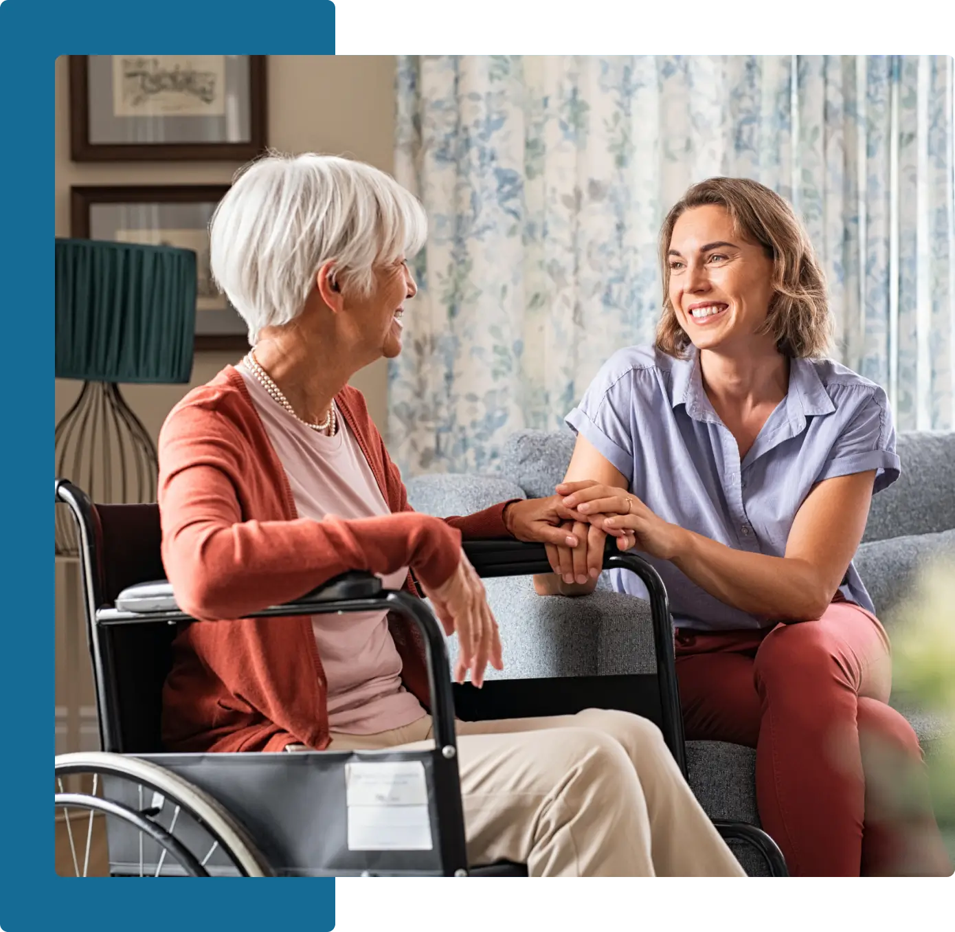 A woman sitting on the lap of an older lady in a wheelchair.